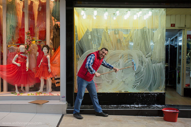 portrait d'un homme lavant les vitrines d'un magasin